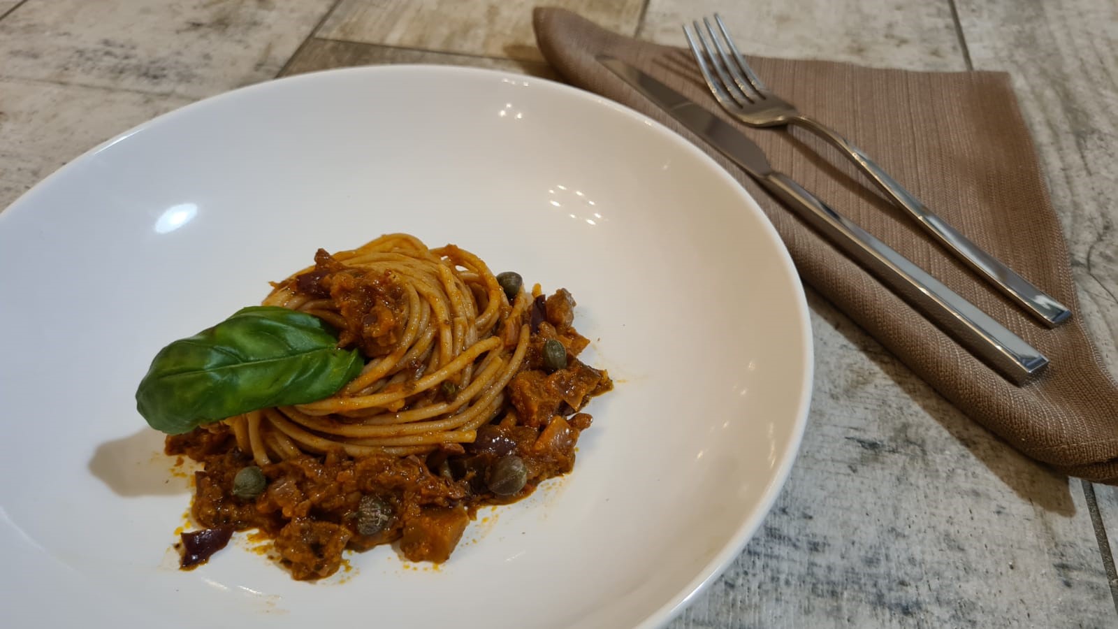 Spaghetti integrali con melanzane, olive e capperi